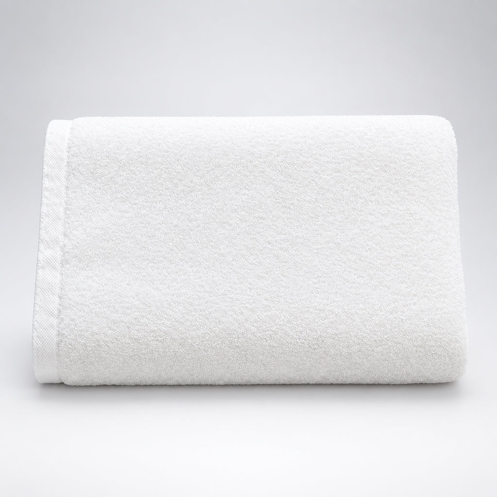Hotel White Bath Towel folded on a dark wooden table