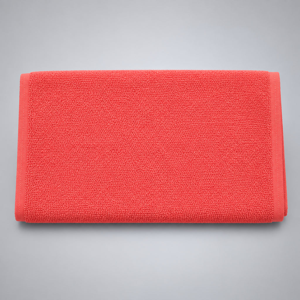 Coral Orange Loop Terry Kitchen Towel folded, a soft salmon colour