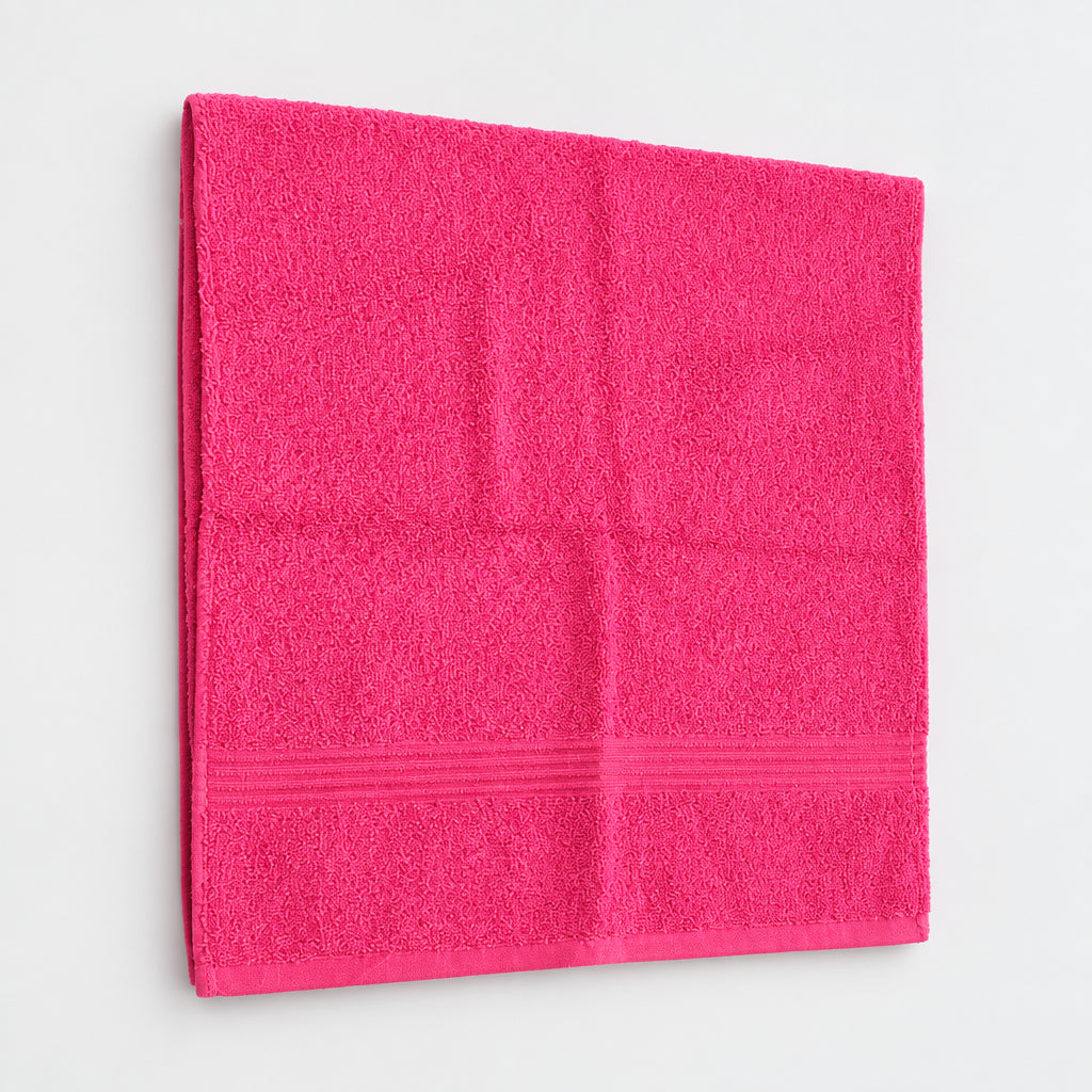 Hot Pink Gym and Face Towel hanging against a white wall
