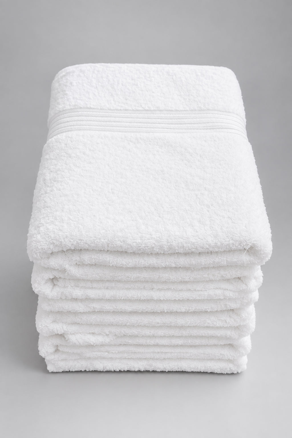 Stack of white Home Bath Towels on a table