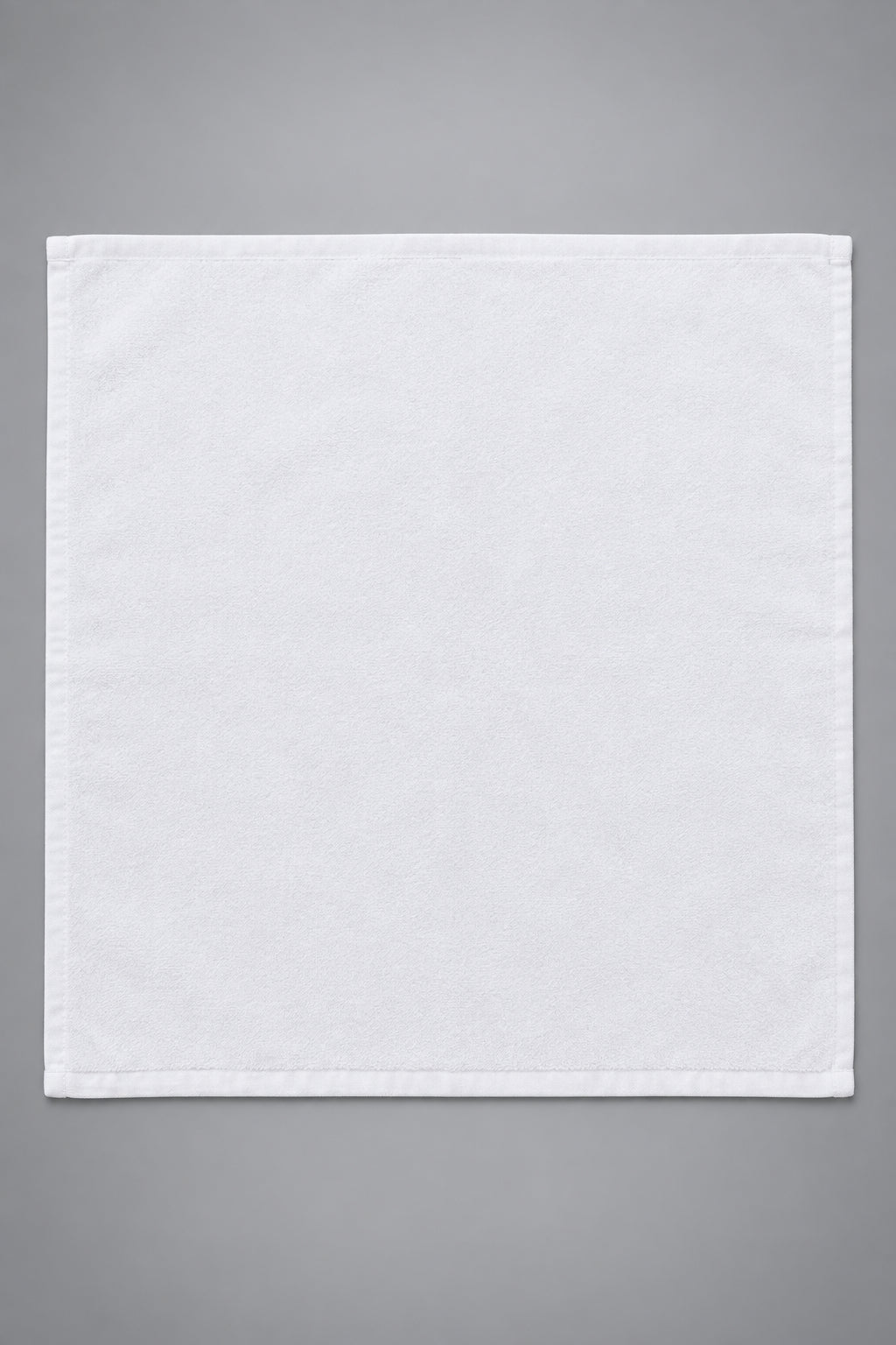 Single White Washcloth laid flat on a wooden table