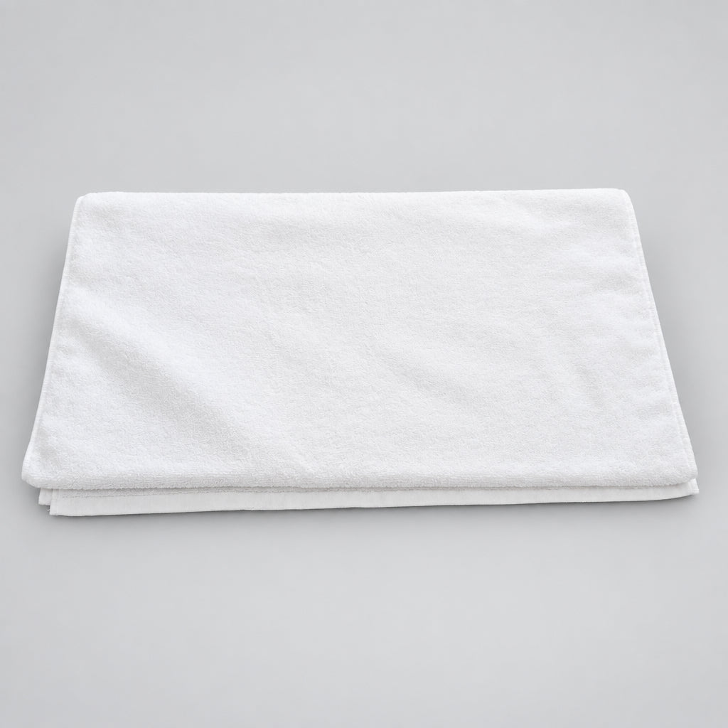 Hotel White Bath Towel folded in thirds on a wooden table