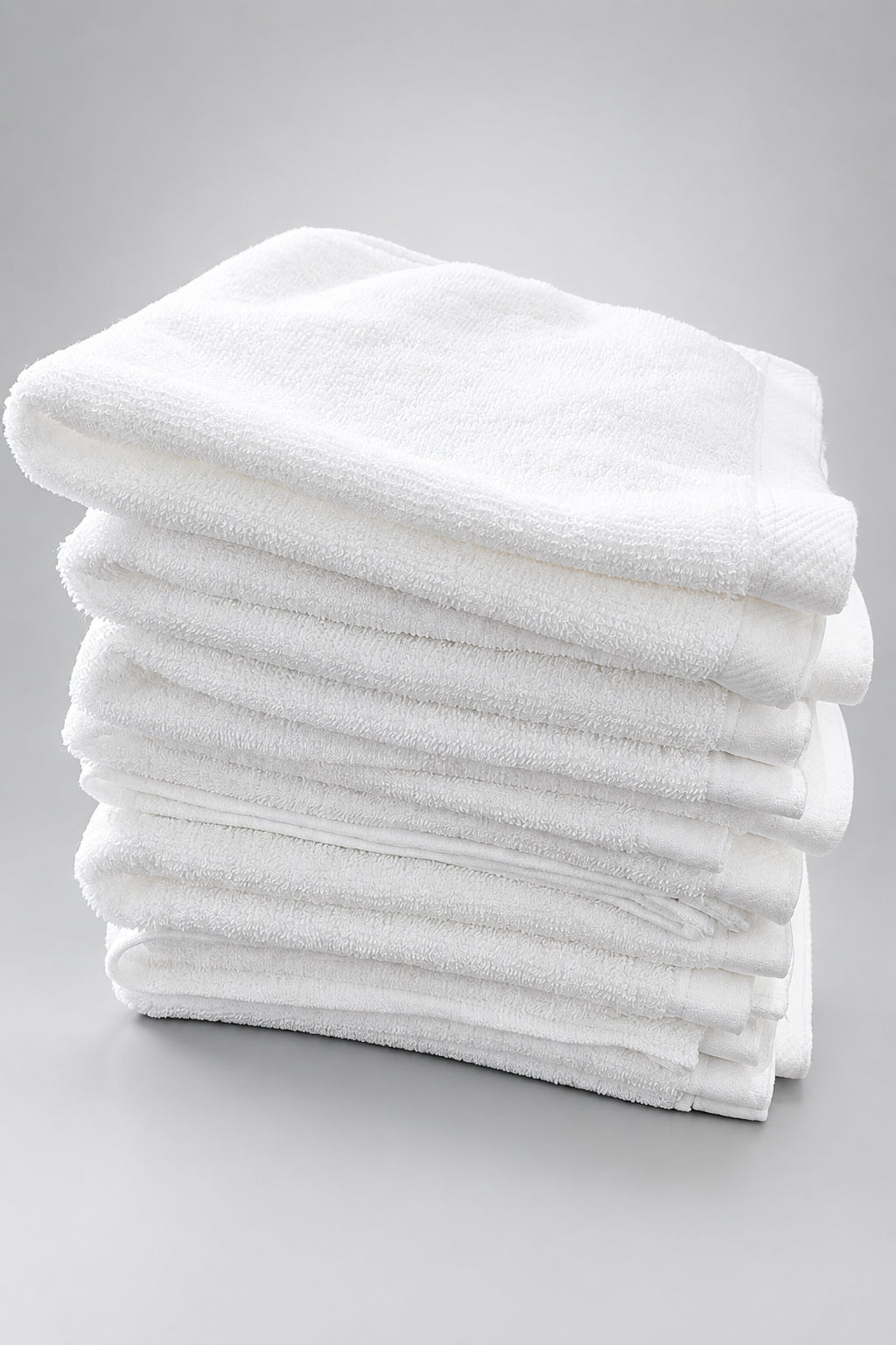 Folded White Washcloths stacked on a wooden table