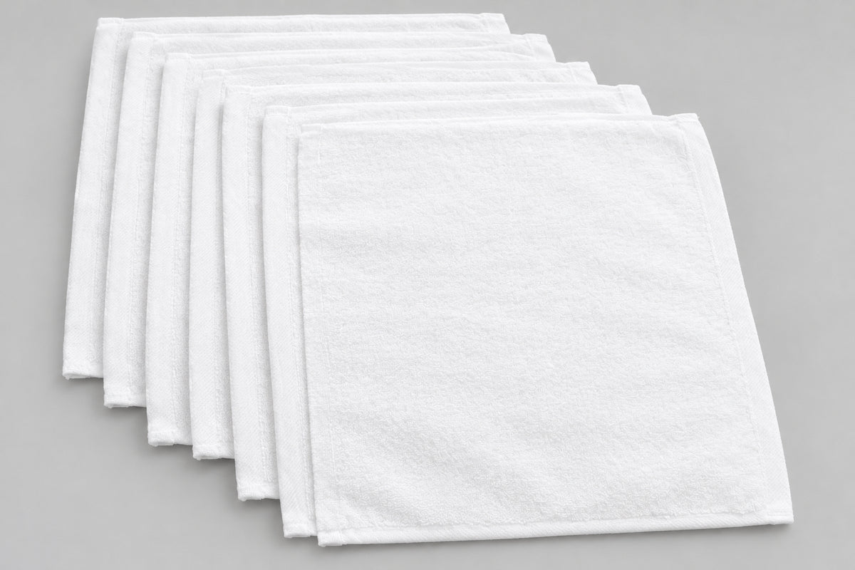 Six White Washcloths fanned out on a dark wooden table